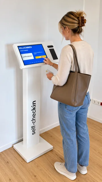 Eine Frau meldet sich am Self-Check-in-Terminal der Praxis an